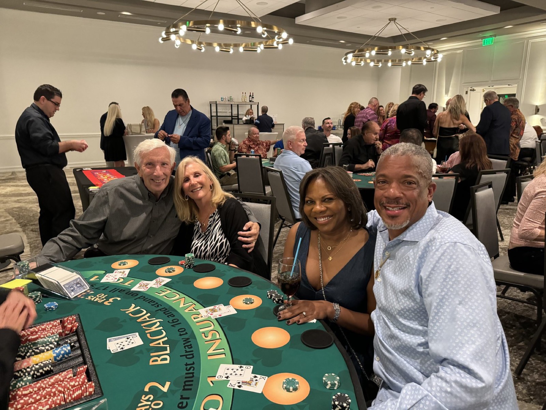 Smiling guests around a blackjack table at a corporate gala