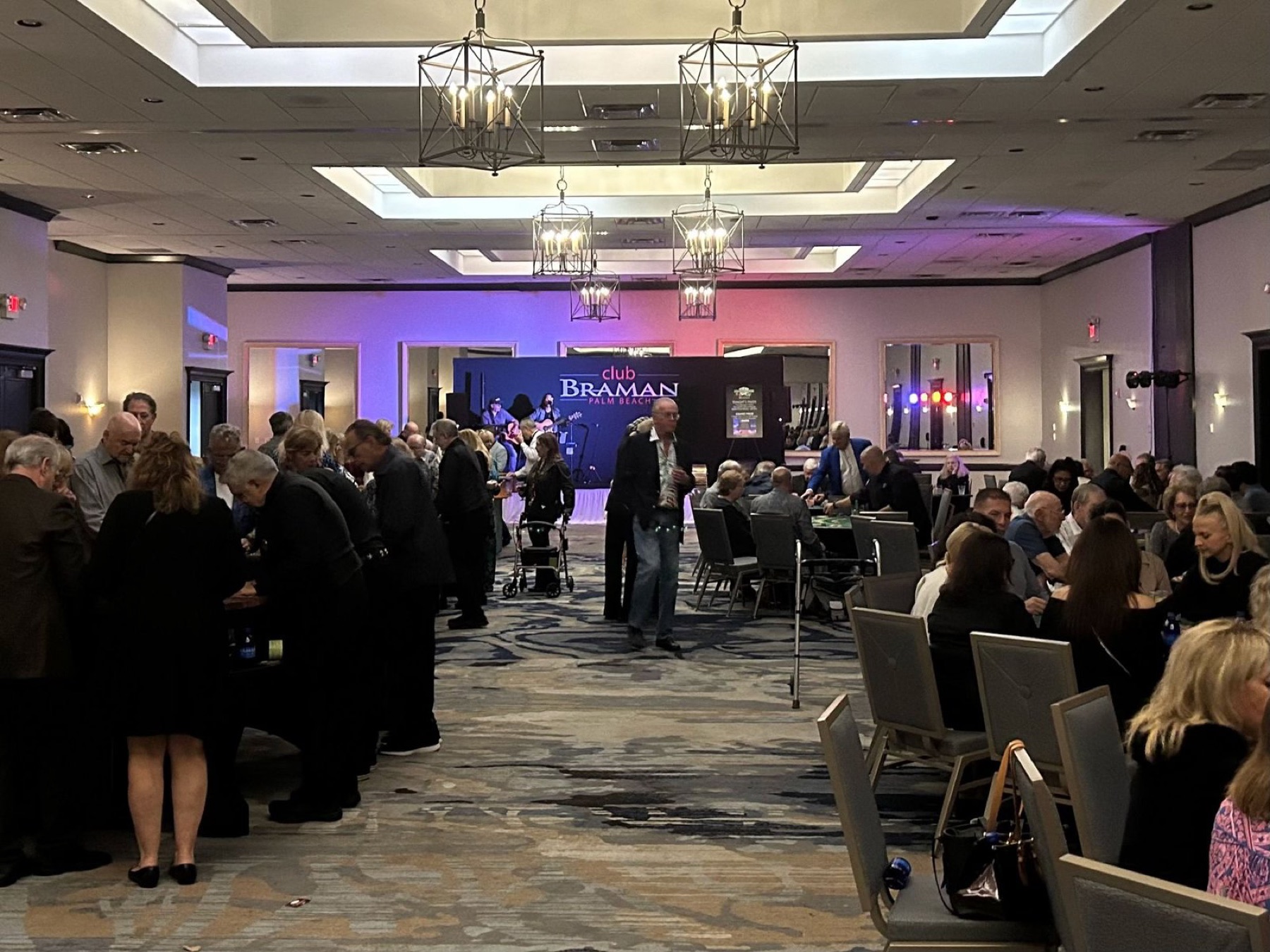 Guests walking between rows of casino tables at a gala