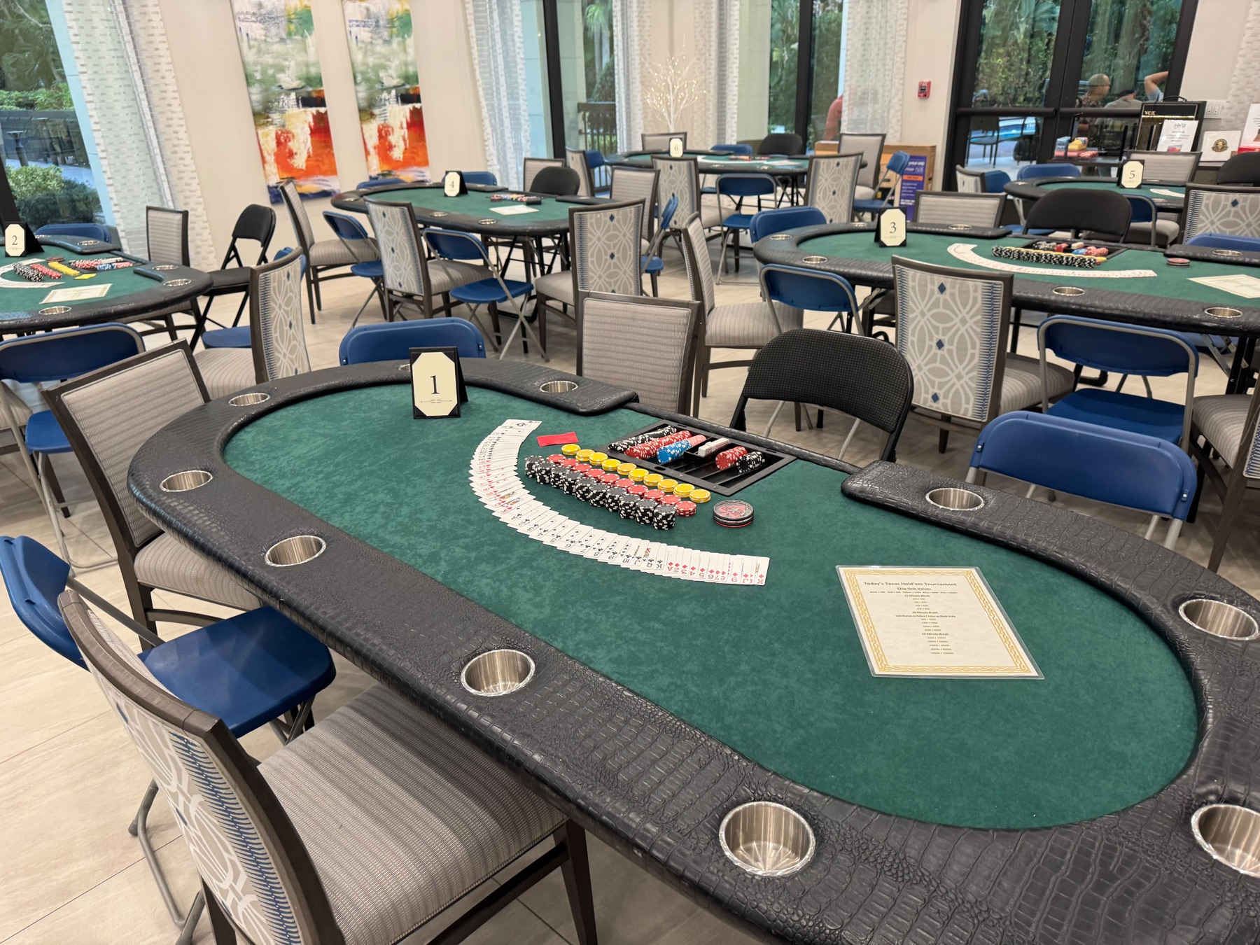 Event room with full-size poker tables set up and chips racked before guests arrive
